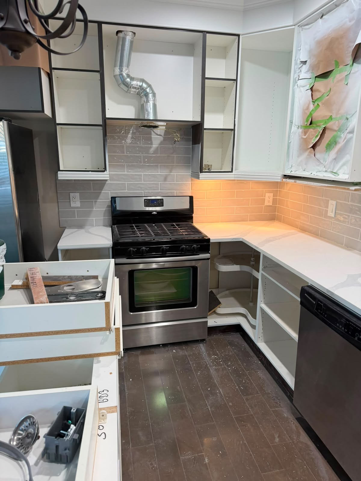 Kitchen renovation in progress with new cabinets and tile backsplash